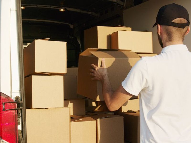 Mensajero uniformado cargando cajas en la van