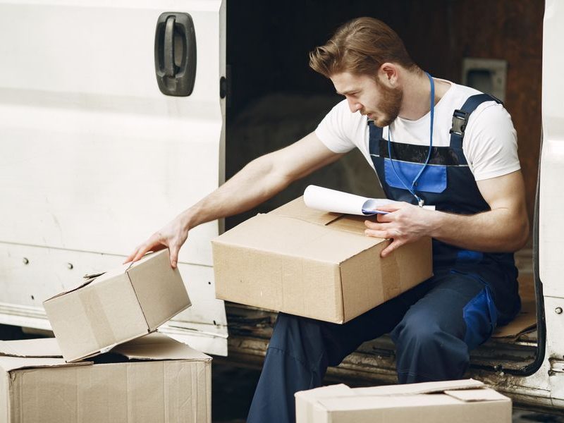Trabajador uniformado organizando cajas para recogida